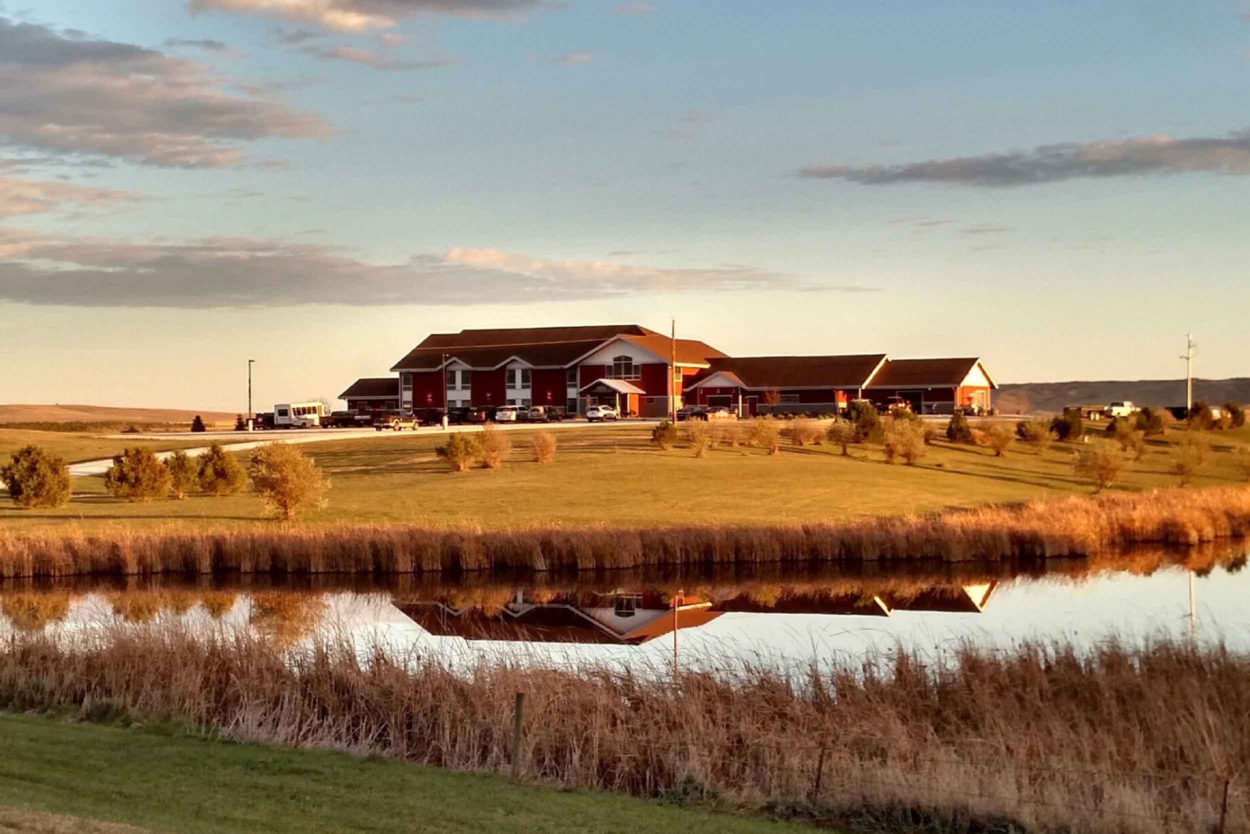 The lodge at golden hour reflected in the pond