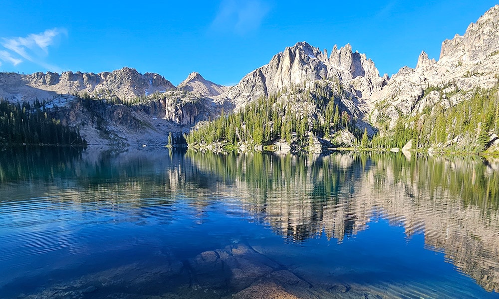 Deep blue alpine lake mirroring the granite peaks above it