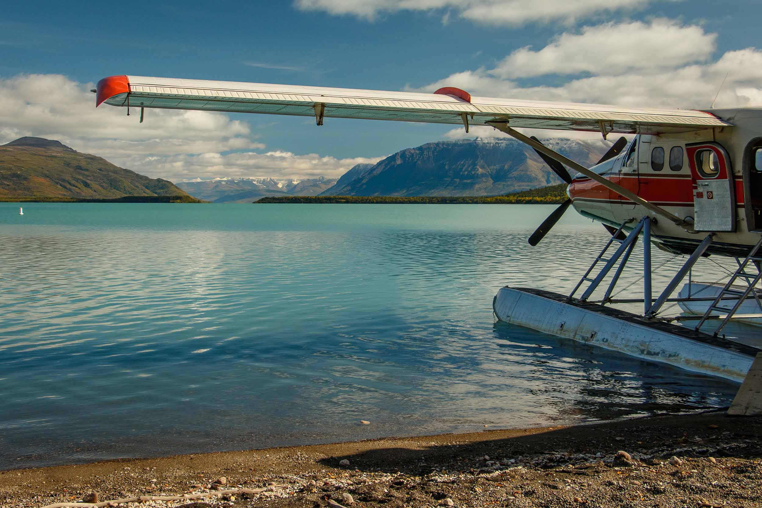 Floatplane moored at a lake shore below the mountains
