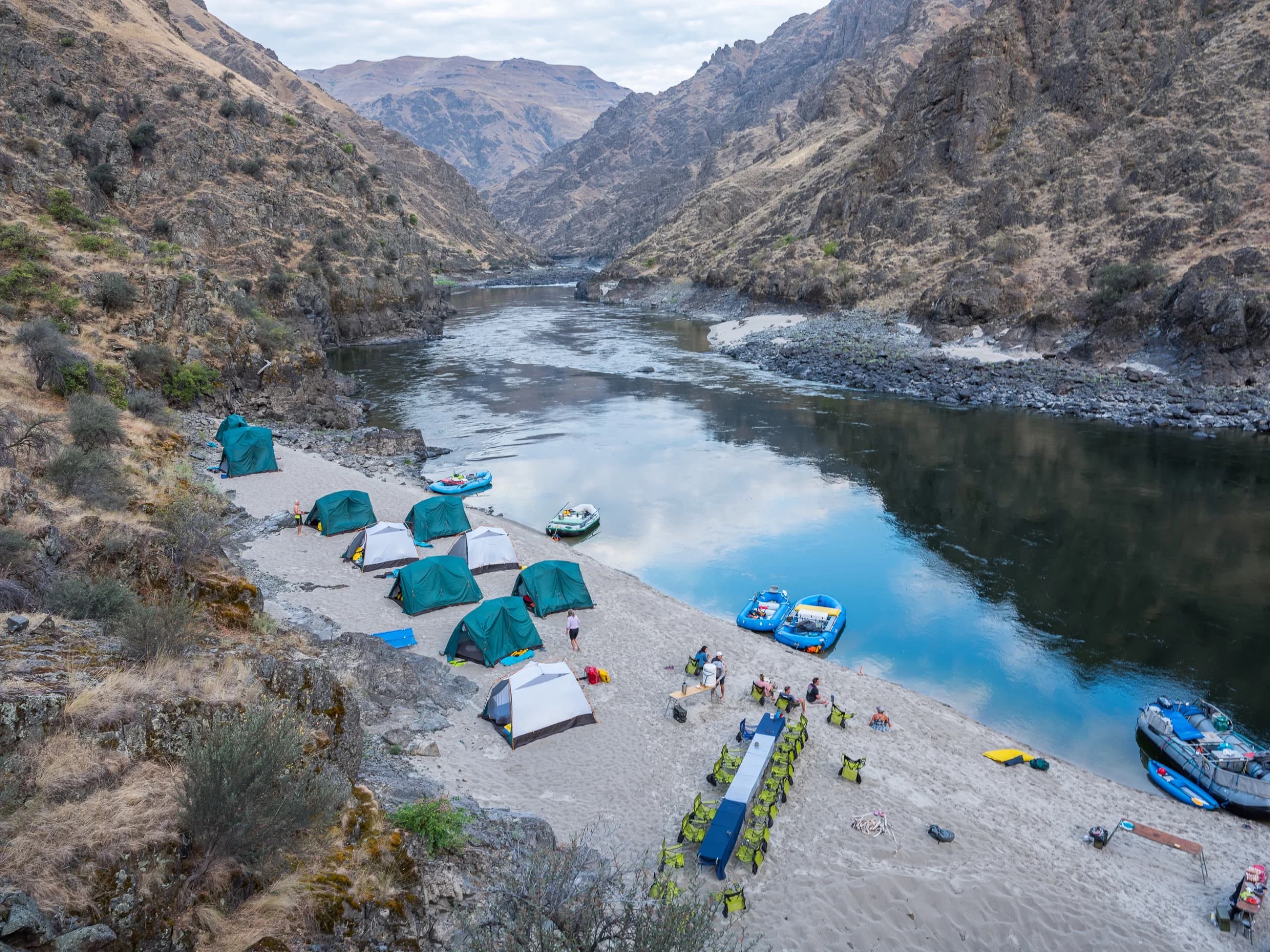 Beach camp of tents and rafts on a sandbar, seen from above