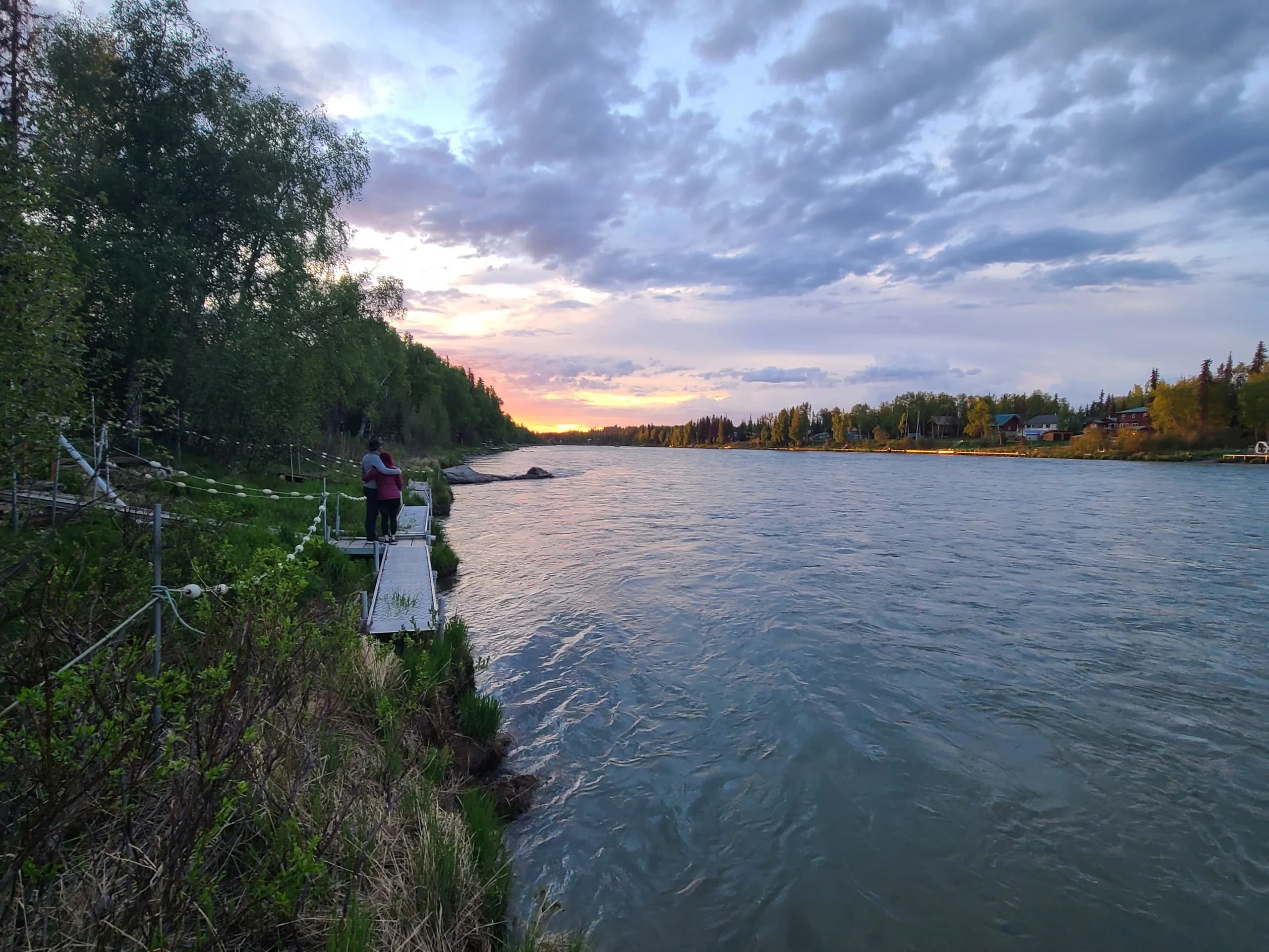 Angler on the Kenai bank at sunset with autumn colour along the far shore